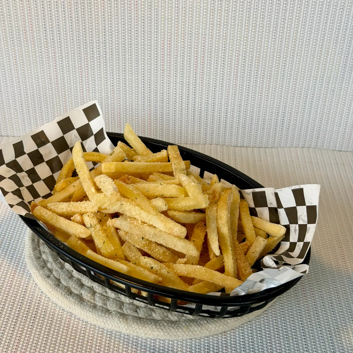 A basket of NamNam seasoned Barkada fries lined with checkered paper